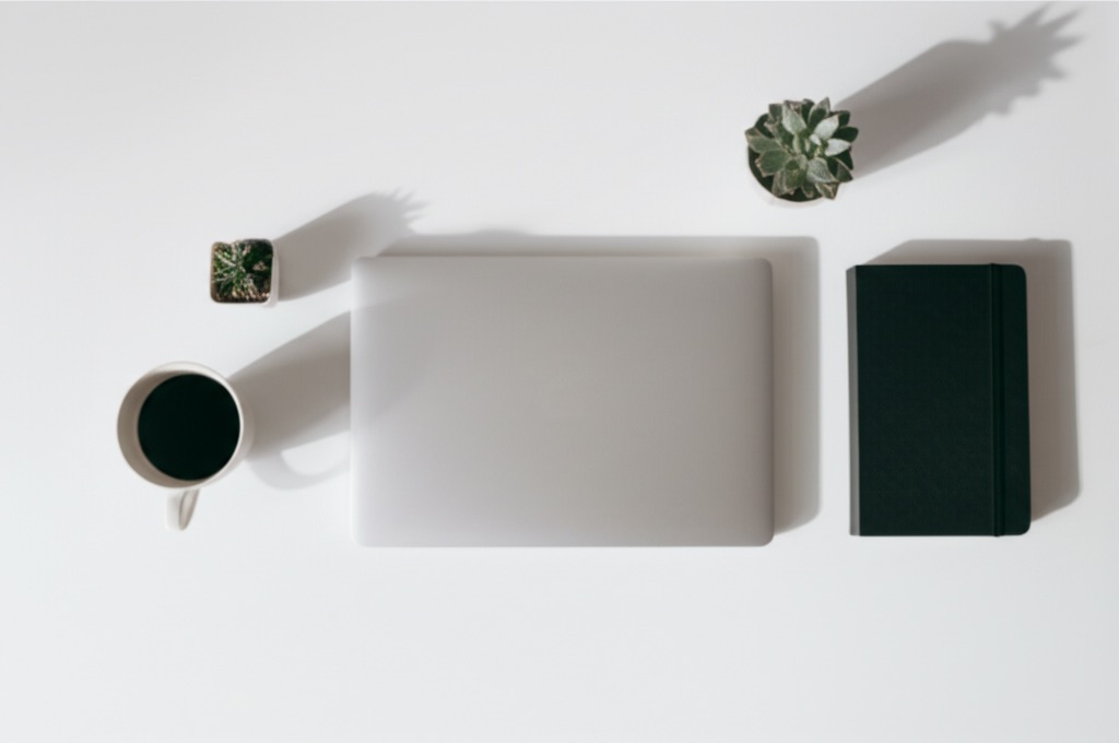 Clean workspace with laptop, coffee, and notebook
